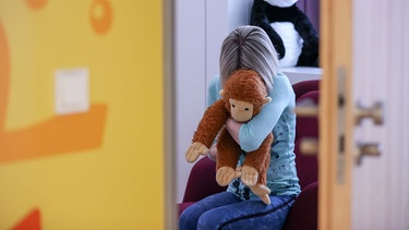 Ein Kind mit einem Kuscheltier im Kinderzimmer. | Bild: picture alliance/dpa | Jan Woitas