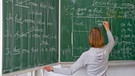 Eine Englisch-Lehrerin schreibt in einer Grundschule an die Tafel. | Bild: dpa-Bildfunk/Patrick Pleul