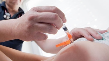 Ein Kinderarzt impft ein einjähriges Kind in den Oberschenkel gegen Masern (Archivbild). | Bild: dpa-Bildfunk/Julian Stratenschulte