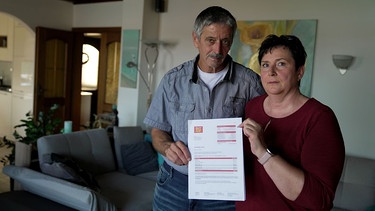 Ehepaar zeigt ein Schreiben ihres Energieanbieters | Bild: BR / Kontrovers | Johannes Lenz