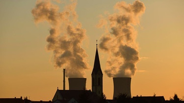 Manches hat sich in Sachen Klimaneutralität schon getan in Bayern: Die Kirche von Röthlein vor dem ehemaligen Kernkraftwerk Grafenrheinfeld, das 2015 stillgelegt wurde (Archivbild)  | Bild: picture alliance / imageBROKER | Lilly