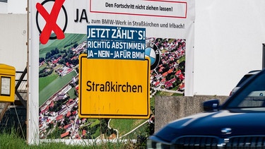 "Ja zum BMW-Werk in Straßkirchen und Irlbach!" steht auf einem Plakat in Straßkirchen.  | Bild: picture alliance/dpa | Armin Weigel