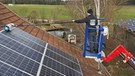 Professionelle Reinigung von Photovoltaik-Paneelen auf einem Bauernhofdach | Bild: Bayerischer Rundfunk