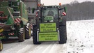 Traktor mit montiertem Transparent mit der Aufschrift: "Ich tanke 100% Pflanzenöl Co2-neutral". | Bild: BR/Ulrich Detsch