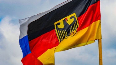 Symbolbild: deutsche Fahne mit angenähten russischen Farben | Bild: picture alliance / Winfried Rothermel | Winfried Rothermel