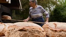 Bäuerin Resi Reichl holt ihr frischgebackenes Brot aus dem Ofen | Bild: BR