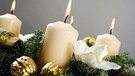 Vier weiße Kerzen auf einem Adventskranz | Bild: MEV/Creativstudio