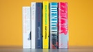 Die Shortlist zum Deutschen Buchpreis 2021: sechs nebeneinander stehende Bücher vor gelbem Hintergrund | Bild: Deutscher Buchpreis