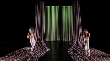 Zwei Schauspielerinnen stehen bei der Perfomance in der Nürnberger Tafelhalle auf der Bühne. | Bild: KunstKulturQuartier