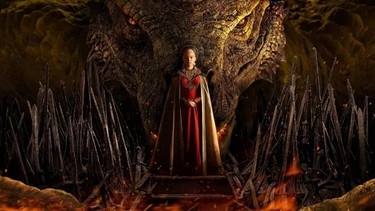 Eine rotgewandete Königin inmitten von nach oben gerichteten Stoßzähnen, hinter ihr ein Drache.  | Bild: Bildrechte: HBO