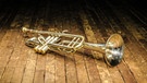 Eine Trompete liegt auf einem Holzboden (Symbolbild) | Bild: picture alliance / Zoonar | Viacheslav Chernobrovin