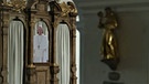 Der Papst als Pappfigur im Beichtstuhl in der Kirche Mariä Geburt in Rottenbuch im Landkreis Weilheim-Schongau.  | Bild: BR 