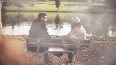 Ein Mann sitzt mit seinem Vater auf einer Parkbank | Bild: picture-alliance/dpa