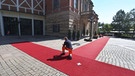 Bayreuth: Der Rote Teppich wird für die Eröffnung der Bayreuther Richard-Wagner-Festspiele, vor dem Festspielhaus auf dem Grünen Hügel befestigt. | Bild: dpa-Bildfunk/Karl-Josef Hildenbrand