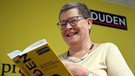 Duden-Redaktionsleiterin mit einem Exemplar des Wörterbuchs | Bild: Wolfgang Kumm/Picture Alliance
