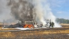 Einsatzkräfte einer Feuerwehr löschen einen brennenden Traktor und eine Strohpresse. | Bild: dpa-Bildfunk/-
