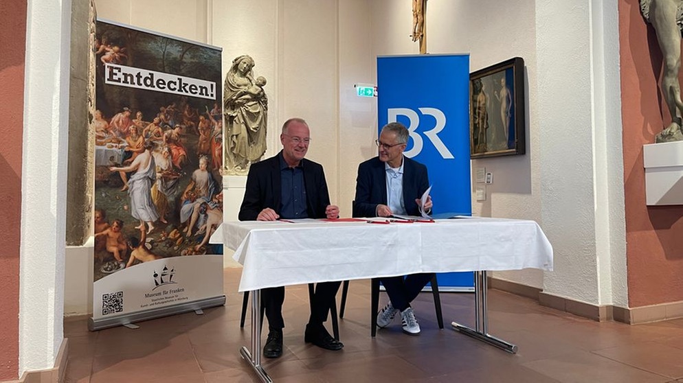 Jörg Meißner (links) und Tassilo Forchheimer (rechts) unterschreiben den Kulturpartnerschaftsvertrag im Museum für Franken | Bild: BR/Silva Schreiner
