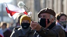 Ein Demonstrant mit einer belarussischen Fahne und einer Blume in der Hand. | Bild: dpa/picture-alliance/Natalia Fedosenko