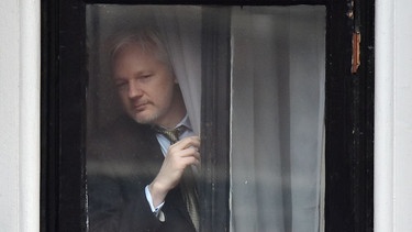 WikiLeaks-Gründer Julian Assange steht an einem Fenster der ecuadorianischen Botschaft.  | Bild: picture-alliance/dpa