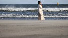 Eine Frau betet an einem Strand bei Fukushima (März 2021) | Bild: picture alliance / ASSOCIATED PRESS | Keita Iijima