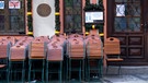 Tische und Stühle stehen vor einem geschlossenen Restaurant in der Innenstadt Münchens. | Bild: picture alliance/dpa | Sven Hoppe
