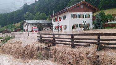 ARCHIV - 17.07.2021, Bayern, Bischofswiesen: Wasser fließt über einen Platz vor einem Haus. | Bild: dpa-Bildfunk/Kilian Pfeiffer