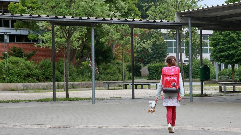 Ein Mädchen geht alleine über einen Schulhof. | Bild: picture alliance / dpa-tmn | Mascha Brichta