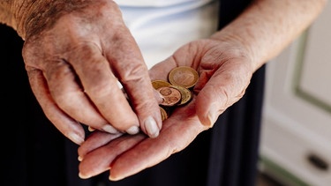 Eine alte Frauenhand zählt Kleingeld. | Bild: BR/Johanna Schlüter