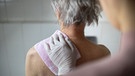 Eine Pflegerin hilft einer Seniorin beim Waschen | Bild: picture alliance/ photothek/ Ute Grabowsky