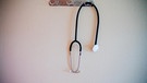 Ein Stethoskop hängt an einer Garderobe.  | Bild: picture alliance/dpa | Christoph Soeder