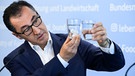 Ernährungsminister Özdemir Özdemir hält zwei Wassergläser in die Höhe, in einem befinden sich Zuckerwürfel. | Bild: dpa-Bildfunk/Bernd von Jutrczenka