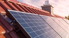 Ein Solarpanel auf dem Dach eines Hauses mit Schornstein | Bild: stock.adobe.com
