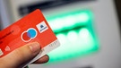 Eine Girocard mit Maestro-Logo wird vor einen Geldautomaten gehalten. | Bild: dpa-Bildfunk/Thomas Banneyer