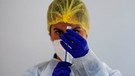 Eine medizinische Fachkraft in Schutzkleidung zieht eine Impfspritze auf | Bild: REUTERS/Jon Nazca