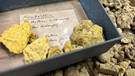 Neben einem handgeschriebenen Etikett liegen Stücke des Minerals Humboldtin.  | Bild: BR/Annerose Zuber