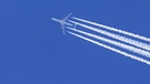 Kondensstreifen aus Triebwerksabgasen, cirrus aviaticus, die sich hinter einem viermotorigen Flugzeug vom Typ Airbus A340 am blauen Himmel bilden; Umweltverträglich? Bericht zeigt Wege für "grünes" Fliegen | Bild: picture alliance / imageBROKER | alimdi / Arterra