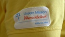 Aufnäher auf dem T-Shirt einer Pflegekraft: "Unsere Mission - Menschlichkeit - Hilfe im Alter" | Bild: BR