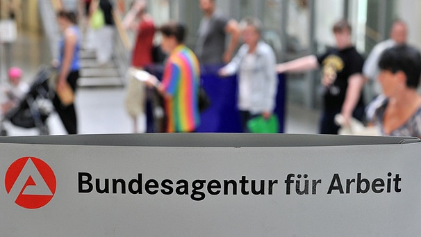 Kunden der Agentur für Arbeit in Leipzig warten an einem Schalter. | Bild: pa/dpa/Hendrik Schmidt
