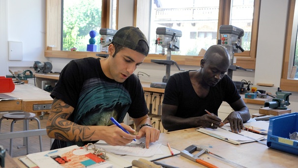 Zwei Flüchtlinge arbeiten in einer Metallbau-Werkstatt in Miesbach | Bild: picture-alliance/dpa