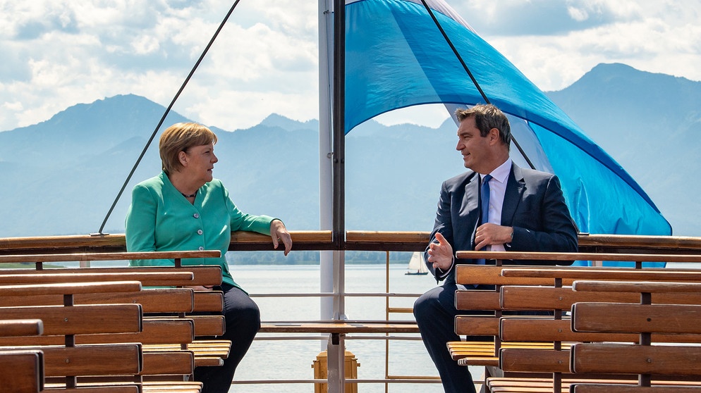 14.07.2020, Bayern, Prien Am Chiemsee: Markus Söder (CSU), Ministerpräsident von Bayern, und Bundeskanzlerin Angela Merkel (CDU), fahren gemeinsam mit einem Schiff der Chiemsee-Schifffahrt auf die Insel Herrenchiemsee. Dort findet die bayerische Kabinettssitzung in der Spiegelgalerie des Neuen Schlosses statt, an der Merkel teilnimmt. Foto: Peter Kneffel/dpa/Pool/dpa +++ dpa-Bildfunk +++ | Bild: dpa-Bildfunk/Peter Kneffel