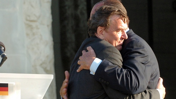 Bundeskanzler Gerhard Schröder (l) und der französische Präsident Jacques Chirac (r) umarmen sich zur Begrüßung vor dem Memorial de la Paix in Caen. (6.6.2004) | Bild: picture-alliance/dpa