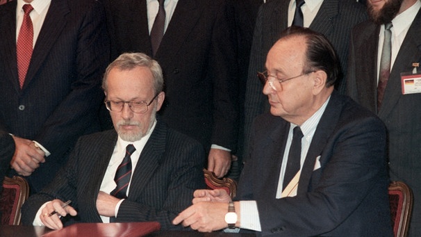  Der deutsche Außenminister Hans-Dietrich Genscher (r) und sein DDR Premierminister Lothar de Maiziere (l) während der Unterzeichnung des Zwei-plus-Vier-Vertrages im Moskauer Hotel "Oktober" am 12. September 1990  | Bild: dpa-Bildfunk/Roland Holschneider