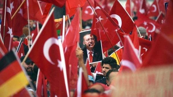 Anhänger des türkischen Staatspräsidenten Erdogan halten am 31.07.2016 in Köln Fahnen hoch. | Bild: dpa/Henning Kaiser