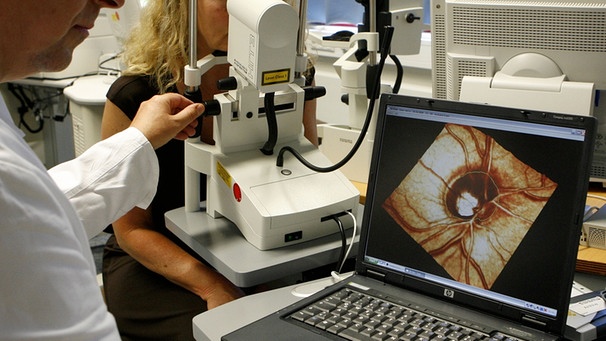 Ein Arzt der Universitäts-Augenklinik in Erlangen (Mittelfranken) führt im Rahmen einer Glaukom-Vorbeugeuntersuchung an einer Frau eine Computeranalyse des Sehnervenkopfes durch | Bild: picture-alliance/dpa