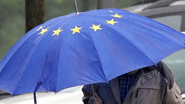 Person mit bauem regenschirm mit EU-Sternen | Bild: picture-alliance/dpa