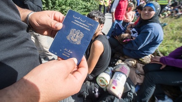 Flüchtling hält Pass in Händen | Bild: picture-alliance/dpa