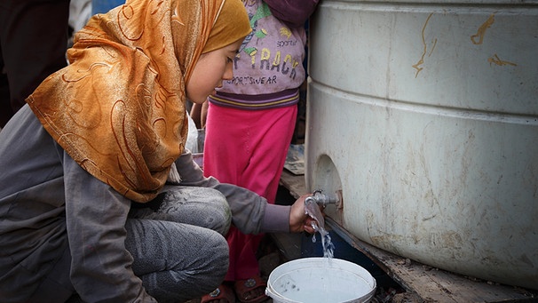 Eine junge Frau, die aus Syrien geflüchtet ist, zapft am 19.03.2015 im Flüchtlingslager der UNHCR in der Bekaa-Ebene im Libanon Wasser. | Bild: picture-alliance/dpa