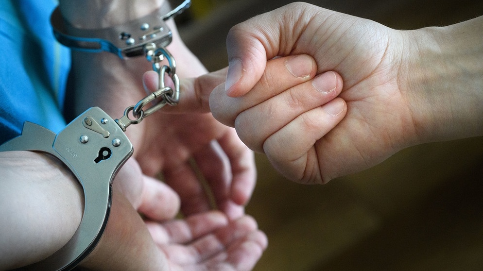 Symbolbild: Ein Haftling in Handschellen wird von einem Wachmann weggeführt | Bild: pa/dpa/Hans-Jürgen Wiedl