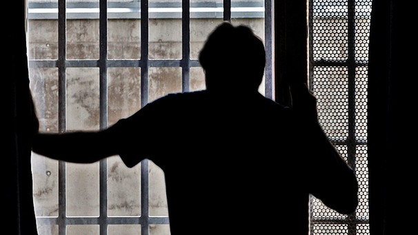 Symbolbild: Ein Mann steht vor einem vergitterten Fenster in einer Justizvollzugsanstalt | Bild: dapd/Mario Vedder