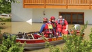 Helfer des DLRG (Deutche Lebensrettungs Gesellschaft) fahren am 05.06.2013 sitzen am 05.06.2013 in einem Boot im überfluteten Deggendorf | Bild: picture-alliance/dpa